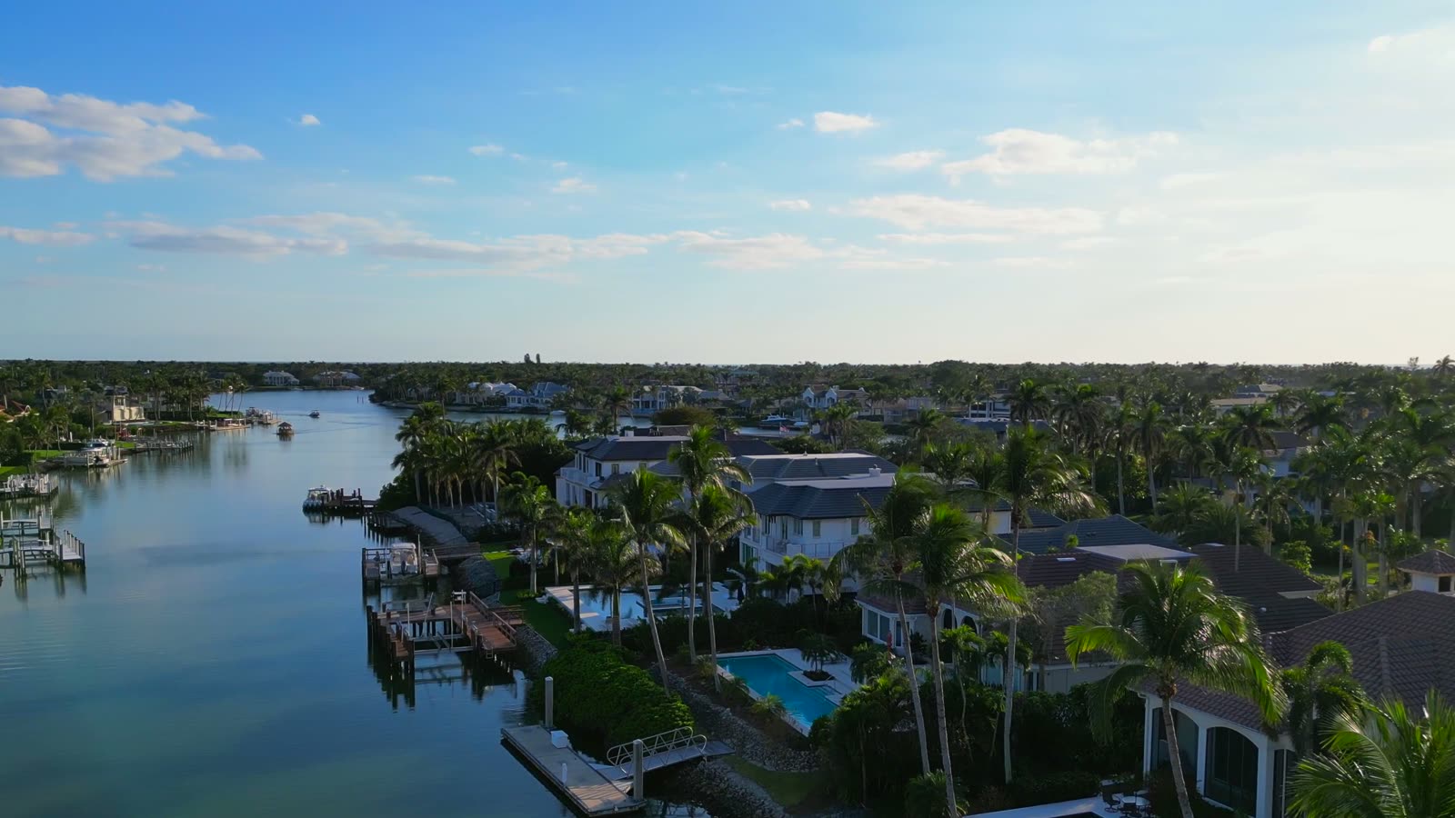 Aerial view along a Naples canal lined with waterfront homes and docks