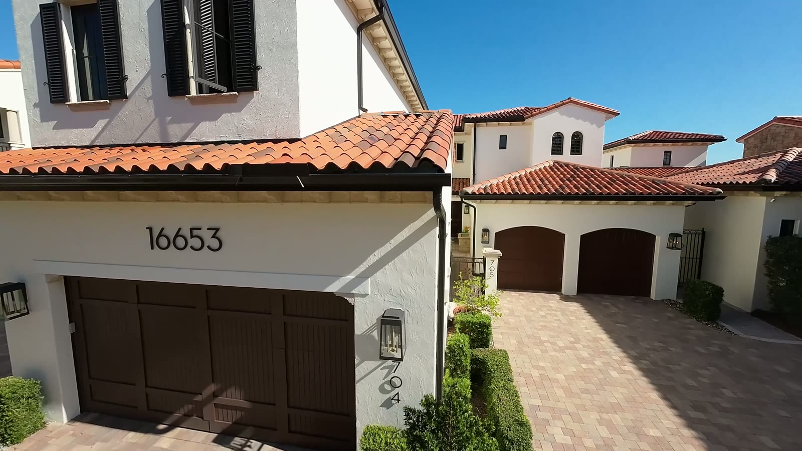 Tile-roofed Mediterranean home with paver driveway